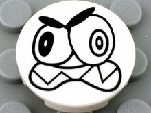 Part 14769pb006 - Tile, Round 2 x 2 with Bottom Stud Holder with Black Large Eyes and Scowl with Sharp Teeth (Nixel Face) Pattern - De BrickPlaats